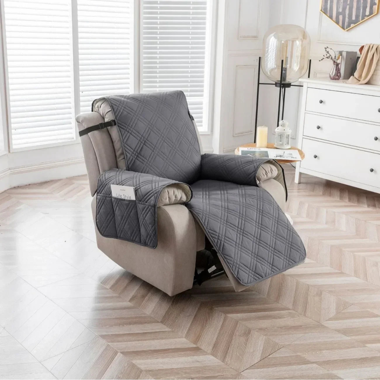 Gray quilted recliner cover in a bright living room
Gray quilted recliner chair cover with side pocket fitted on a beige recliner in a modern living room with wood flooring and white cabinetry