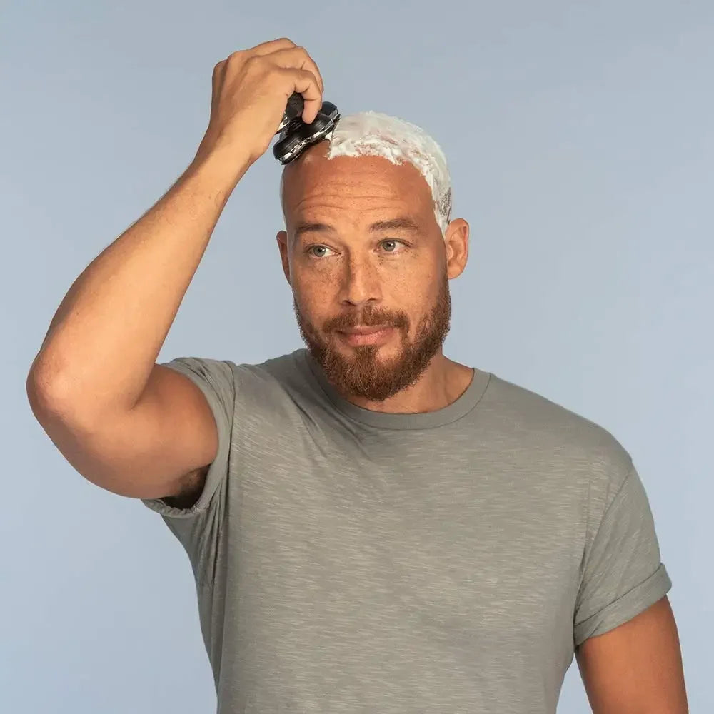 Man using the Balder Pro Head Shaver with shaving cream, demonstrating wet shaving on a bald head.