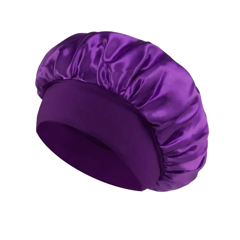 Purple satin sleep bonnet with wide soft band for hair protection on a white background