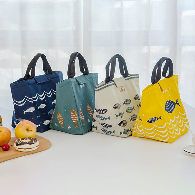 Four colorful insulated lunch bags with fish patterns displayed on a table.