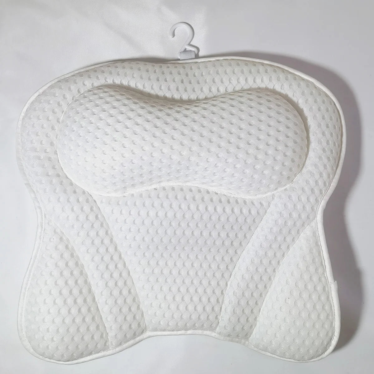White 4D mesh bath pillow with built-in headrest and contoured support, hanging hook visible on white background.