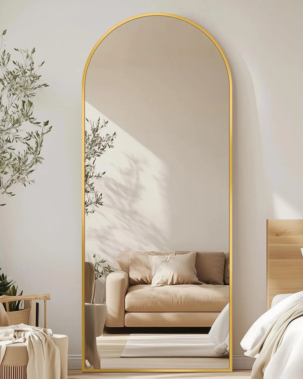 Decorative gold arch mirror in modern bedroom with beige sofa