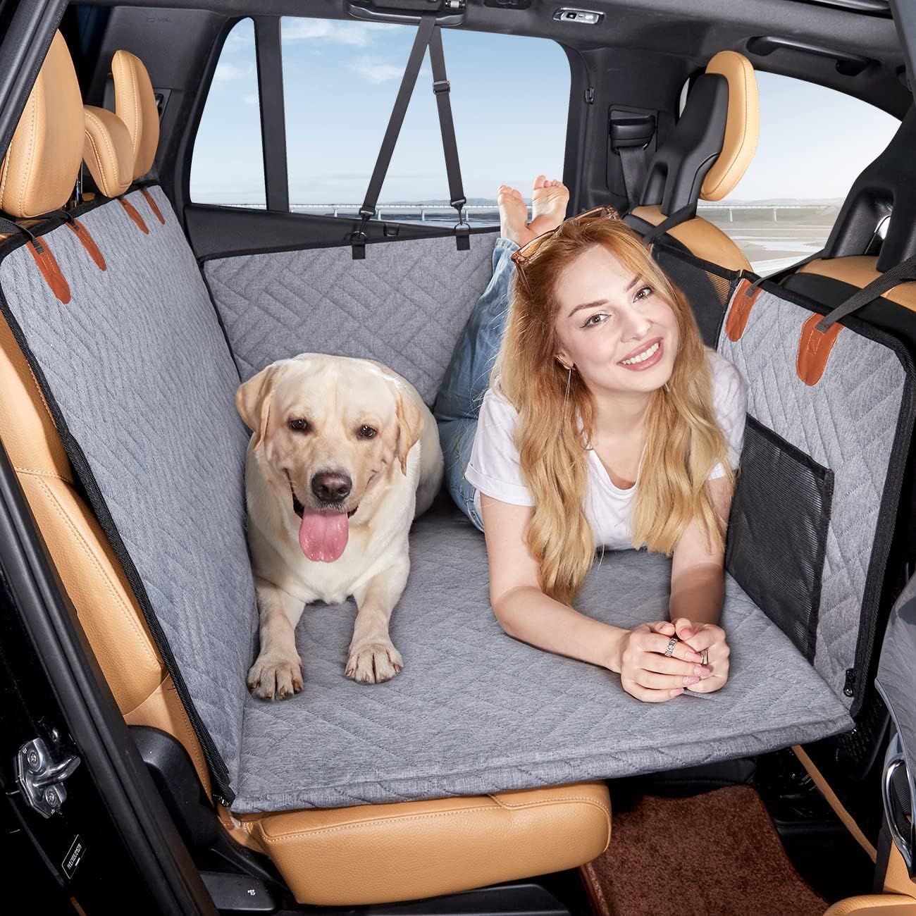 gray quilted back-seat dog bed cover with rigid front support; woman and labrador relaxing in SUV