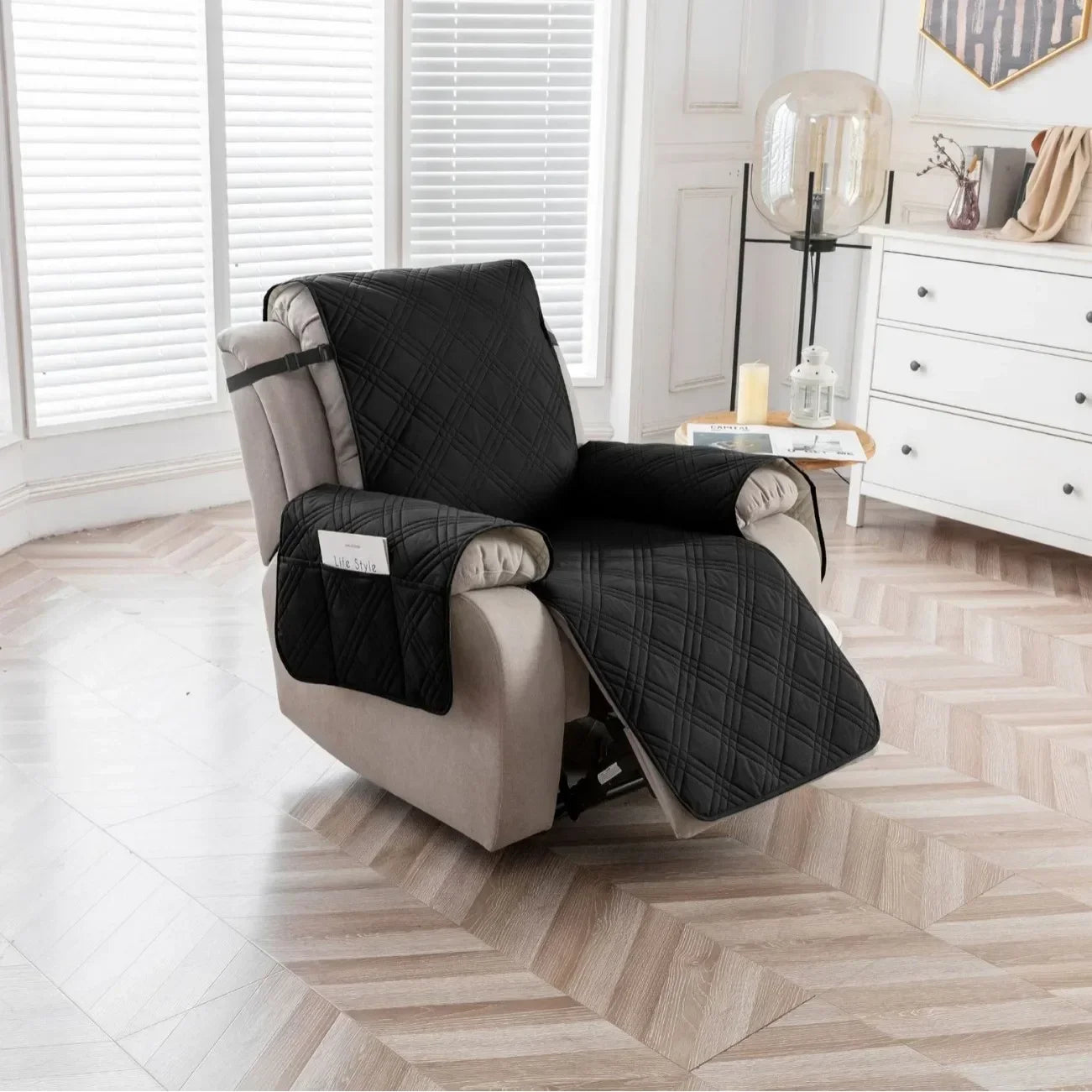 Black quilted recliner chair cover with side pocket fitted on a beige recliner in a modern living room with wood flooring and white cabinetry