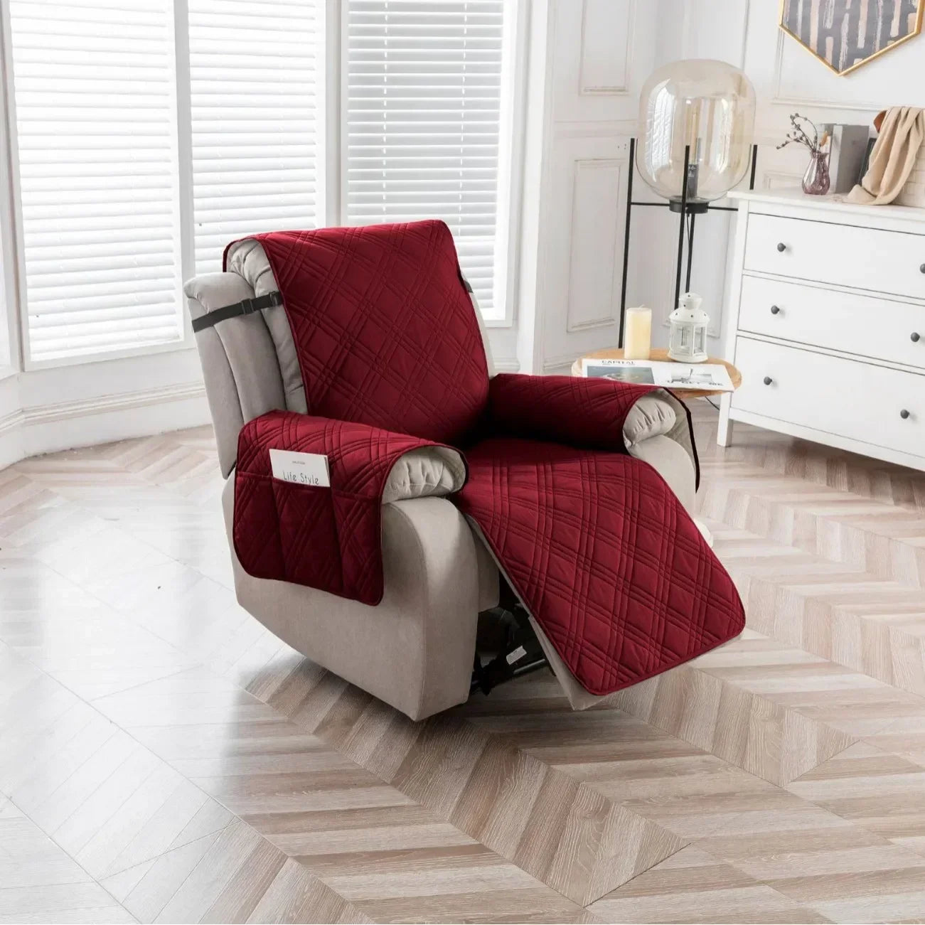 Burgundy quilted recliner chair cover with side pocket fitted on a beige recliner in a modern living room with wood flooring and white cabinetry