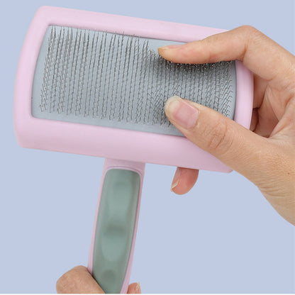 Finger pressing on pink slicker brush to show bristle flexibility