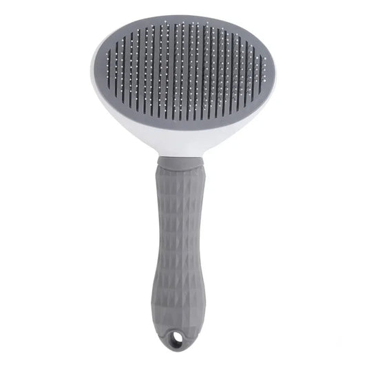 Gray self-cleaning grooming brush with an ergonomic handle and fine metal bristles. Designed to remove loose fur and minimize shedding.