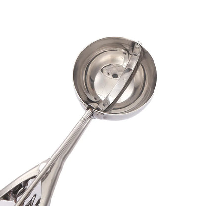 Close-up image of the bowl section of a stainless steel ice cream scoop showing the smooth interior and release lever mechanism.