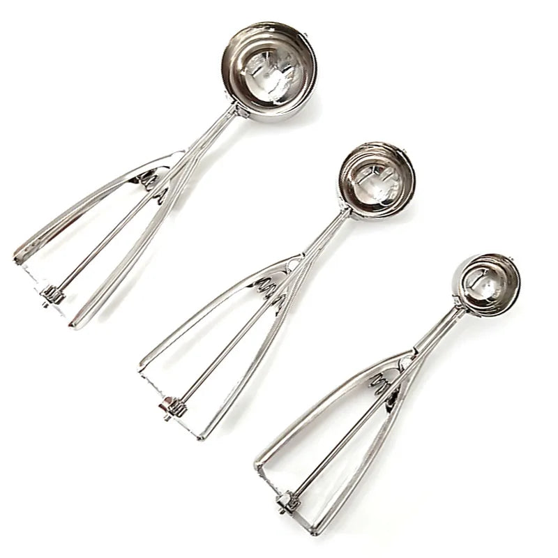 Top view of stainless steel ice cream scoops in three different sizes arranged diagonally for comparison of bowl and handle dimensions.