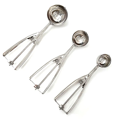 Top view of stainless steel ice cream scoops in three different sizes arranged diagonally for comparison of bowl and handle dimensions.