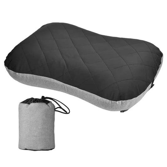 Black inflatable travel pillow with quilted top layer and gray base shown alongside its gray fabric drawstring storage pouch, presented on a white background. The image emphasizes the pillow’s compact, foldable design and suitability for hiking, camping, flights, and portable sleep support.