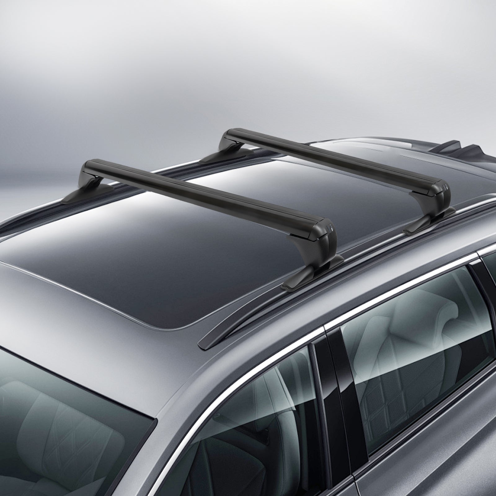 angled view of two black aluminum aerodynamic cross bars clamped at the door frames on a gray SUV roof with panoramic glass; low-drag shape and padded feet visible