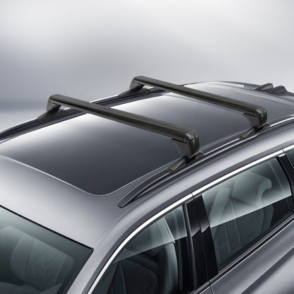 angled view of two black aluminum aerodynamic cross bars clamped at the door frames on a gray SUV roof with panoramic glass; low-drag shape and padded feet visible