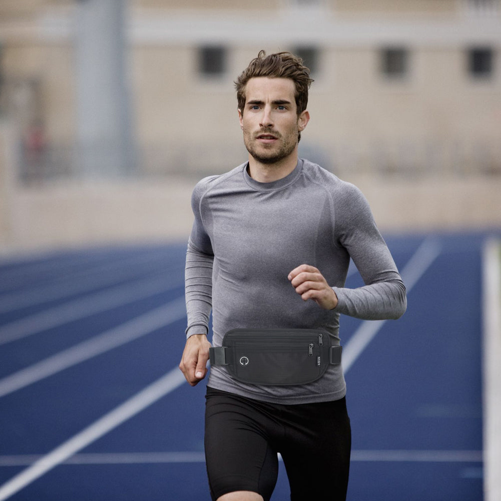 Athletic man jogging on a blue track while wearing a black waist pack around his waist, demonstrating its use during physical activities.