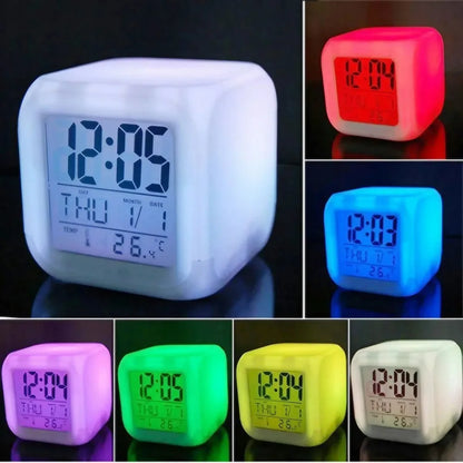 A collection of cube-shaped digital LED alarm clocks glowing in colors like red, green, blue, pink, and yellow, each showing time, date, and temperature with a clear backlit screen.