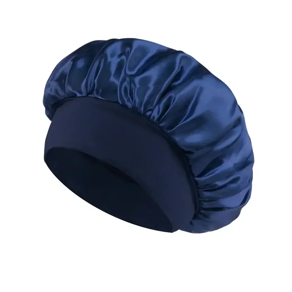 Navy blue satin sleep bonnet with wide soft band for hair protection on a white background