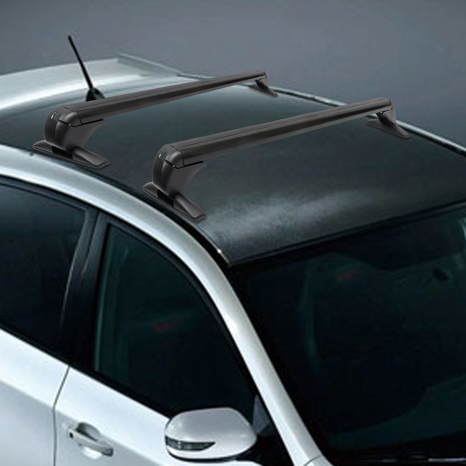 two black roof rack cross bars secured to a dark gray vehicle roof, antenna visible at rear