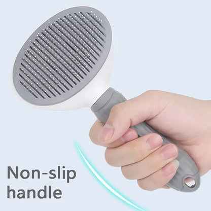 Close-up image of a hand holding the gray grooming brush, emphasizing the comfortable and non-slip handle for easy use.