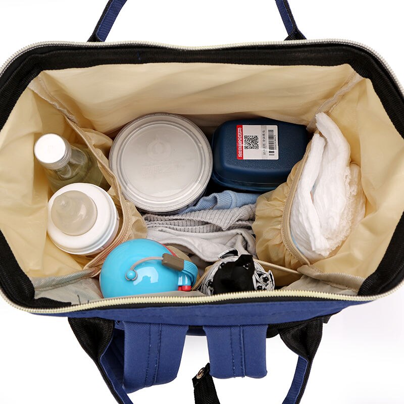 Top view of diaper bag interior filled with bottles, clothes, containers, and diapers.