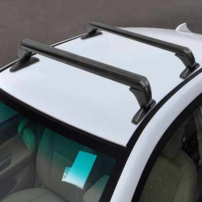angled close-up of two streamlined black cross bars clamped to a white car roof, showing aerodynamic bar shape and padded feet