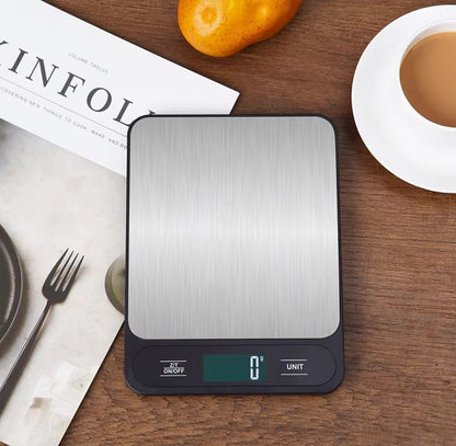 Black stainless steel kitchen scale on countertop with backlit LCD.