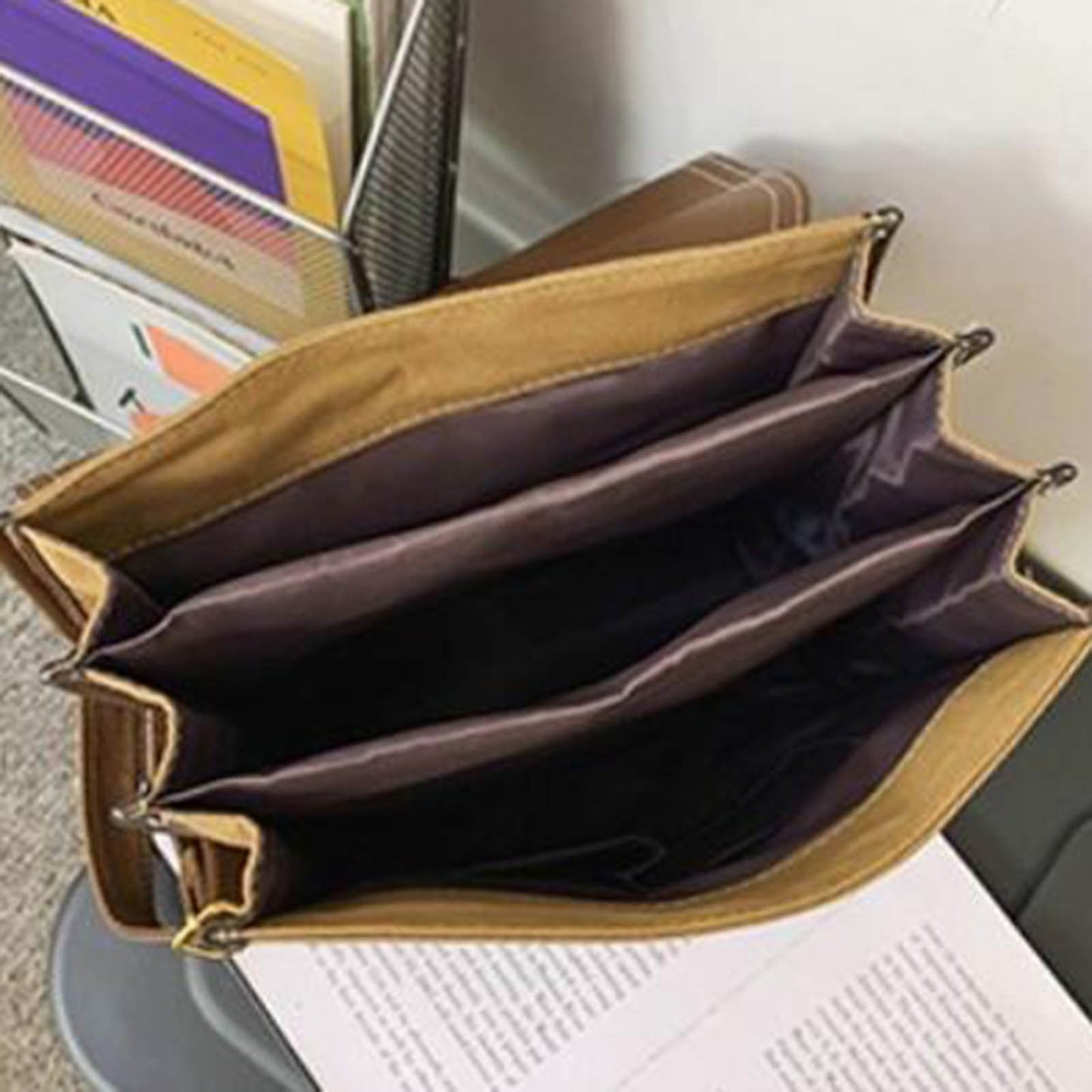 Top-down interior view of the backpack showcasing multiple spacious compartments and brown fabric lining for organized storage.