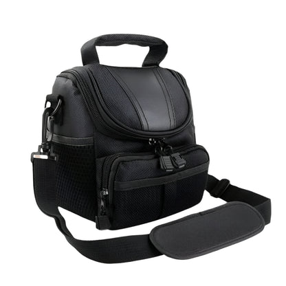 Angled top view of a black waterproof camera bag showing durable stitching, zippered compartments, and an ergonomic shoulder strap pad.