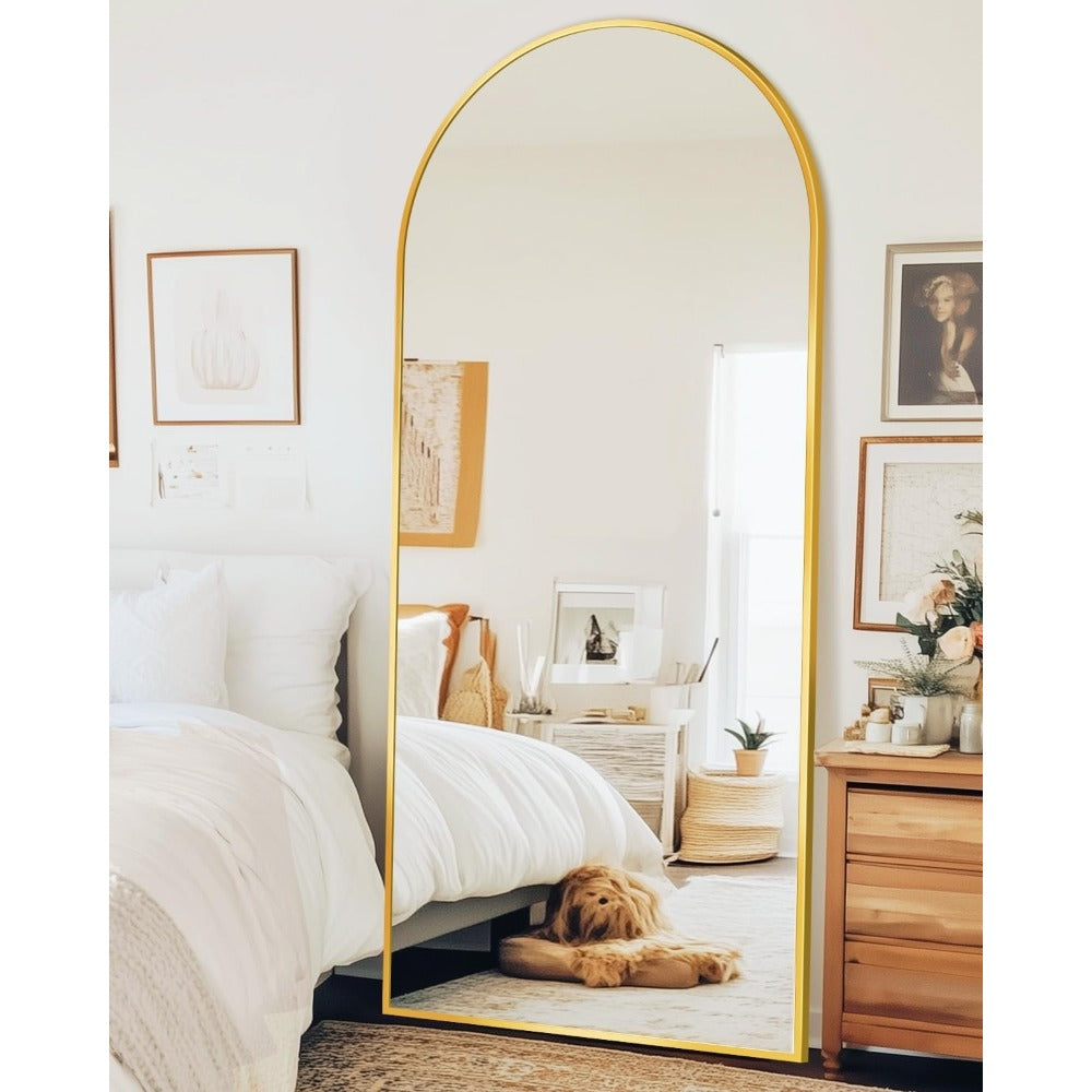 Gold frame arched mirror in cozy bedroom with natural sunlight