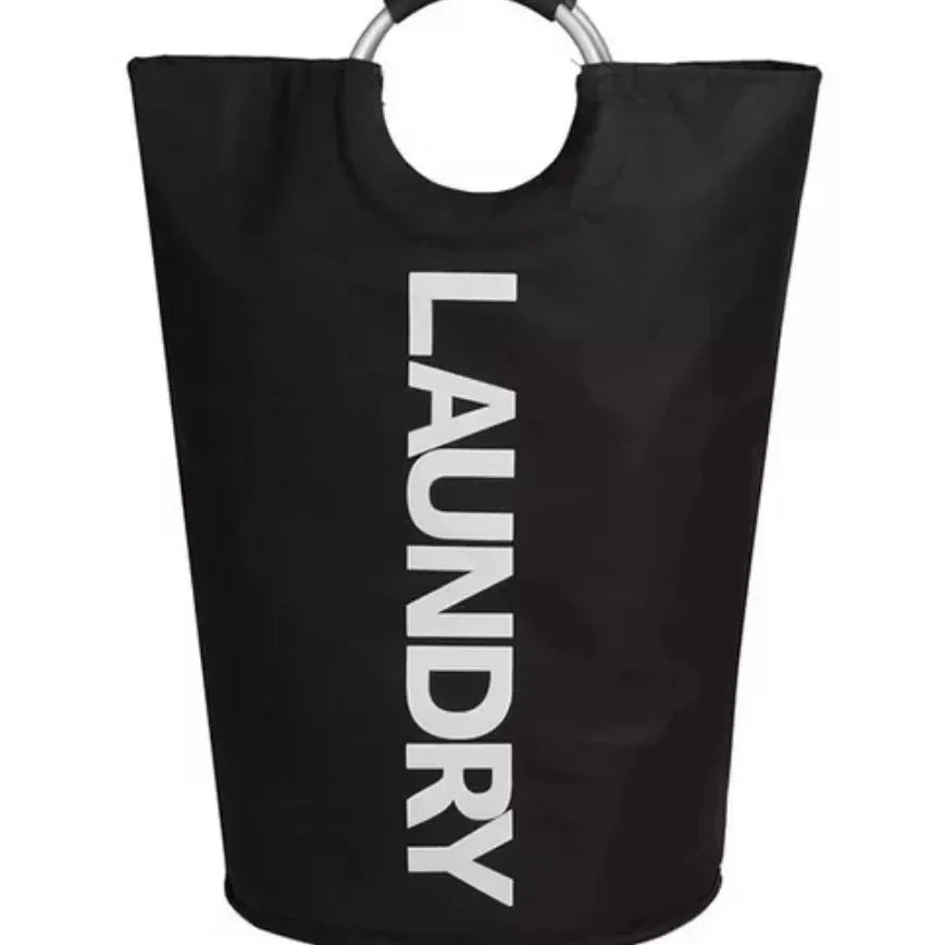 A front-facing view of a black cylindrical laundry hamper with silver ring handles and soft black grips, prominently displaying the word "LAUNDRY" in bold vertical white letters on the front, against a clean white backdrop.