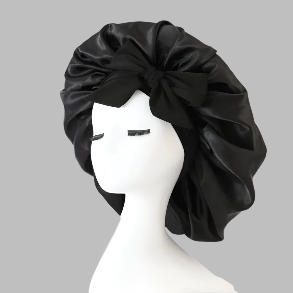 Black satin bonnet styled with bow on white mannequin head