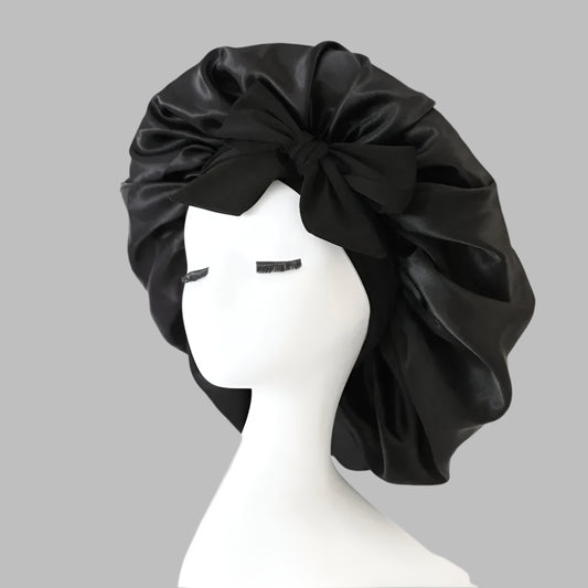Black satin bonnet styled with bow on white mannequin head