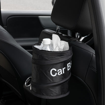 Portable car bin positioned beside the front console of a luxury vehicle, holding drink bottles and tissues, with caption “It holds the trash in place.