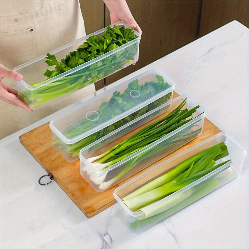 A person holding a transparent food container filled with leafy greens over a wooden cutting board. Three additional containers filled with green onions and herbs are neatly aligned below it, highlighting easy handling and storage.