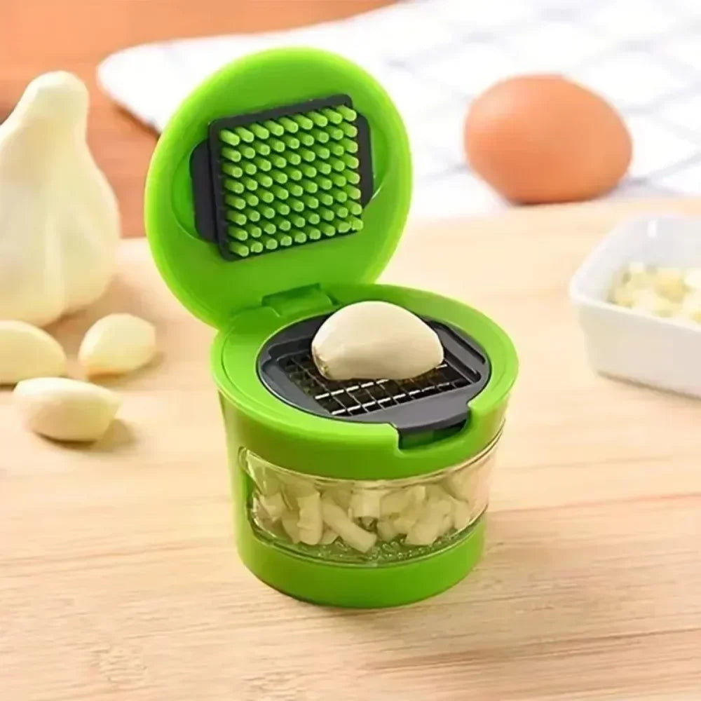 Garlic clove placed on blade inside open green garlic dicer ready to be minced
