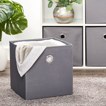 Gray collapsible fabric storage bin with blanket inside, placed in living room setup