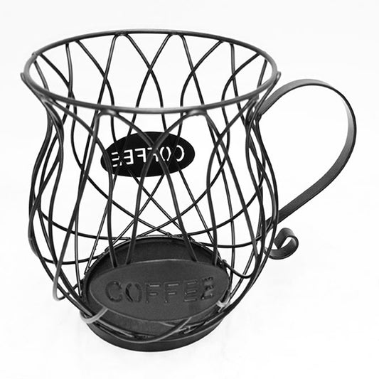 A minimalist black coffee capsule storage basket photographed on a plain white surface, showcasing its curved wire design, "COFFEE" label, and sturdy base from a top angle.