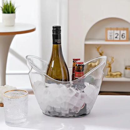 A transparent ice bucket filled with ice, holding one wine bottle and two beer bottles, placed on a dining table in a cozy indoor setting, demonstrating usage in social gatherings.