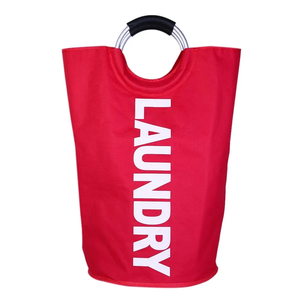 A front-facing image of a bright red cylindrical laundry hamper with the word "LAUNDRY" printed in large white vertical text, featuring silver ring handles with black padding, placed against a plain white background.