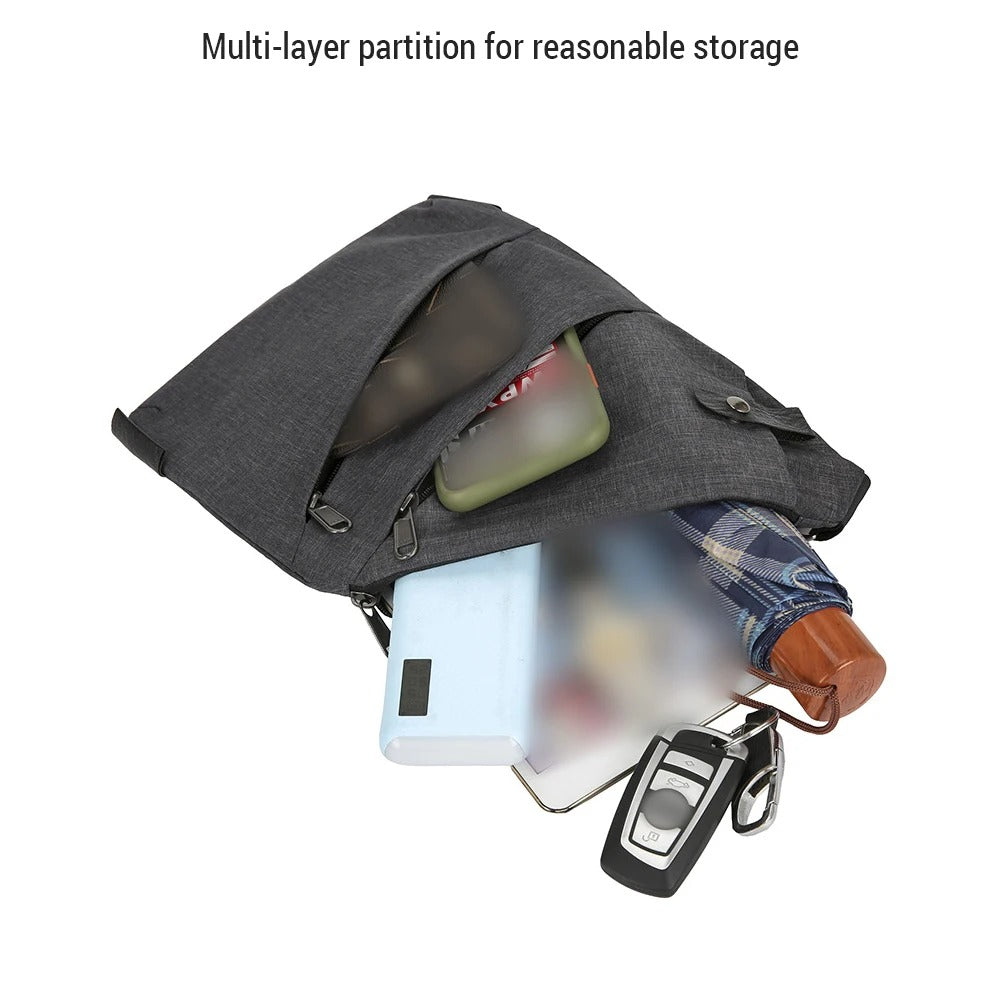 Dark gray crossbody sling bag shown open with contents including a smartphone, watch, umbrella, power bank, and car keys, highlighting its multi-layer compartment design for organized storage.