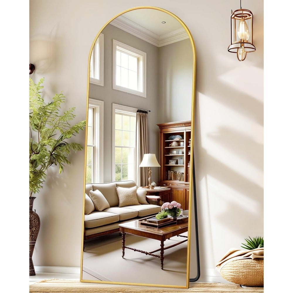 Full body arched mirror reflecting living room furniture and window