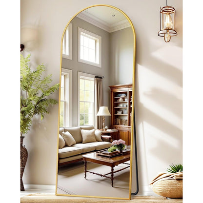 Full body arched mirror reflecting living room furniture and window