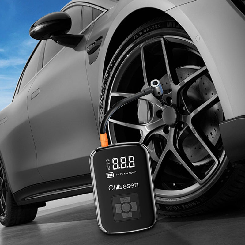 Wireless tire inflator connected to a car wheel on the road, emphasizing sleek and compact design.