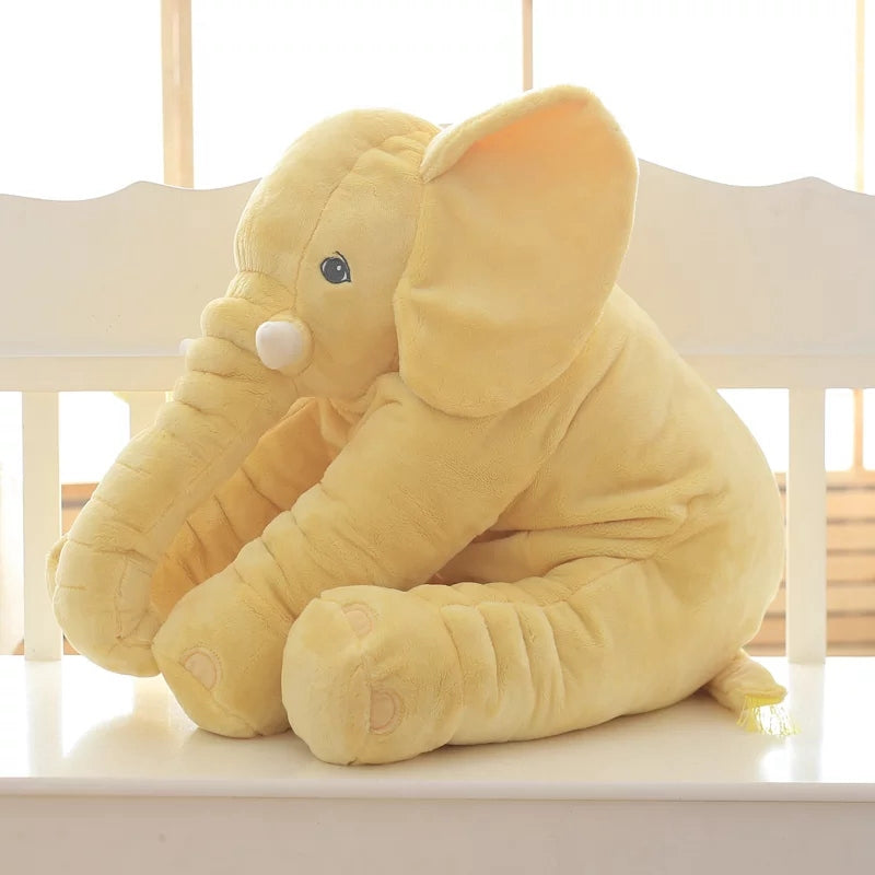 Yellow elephant plush toy sitting on chair by window