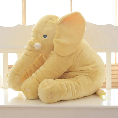 Yellow elephant plush toy sitting on chair by window